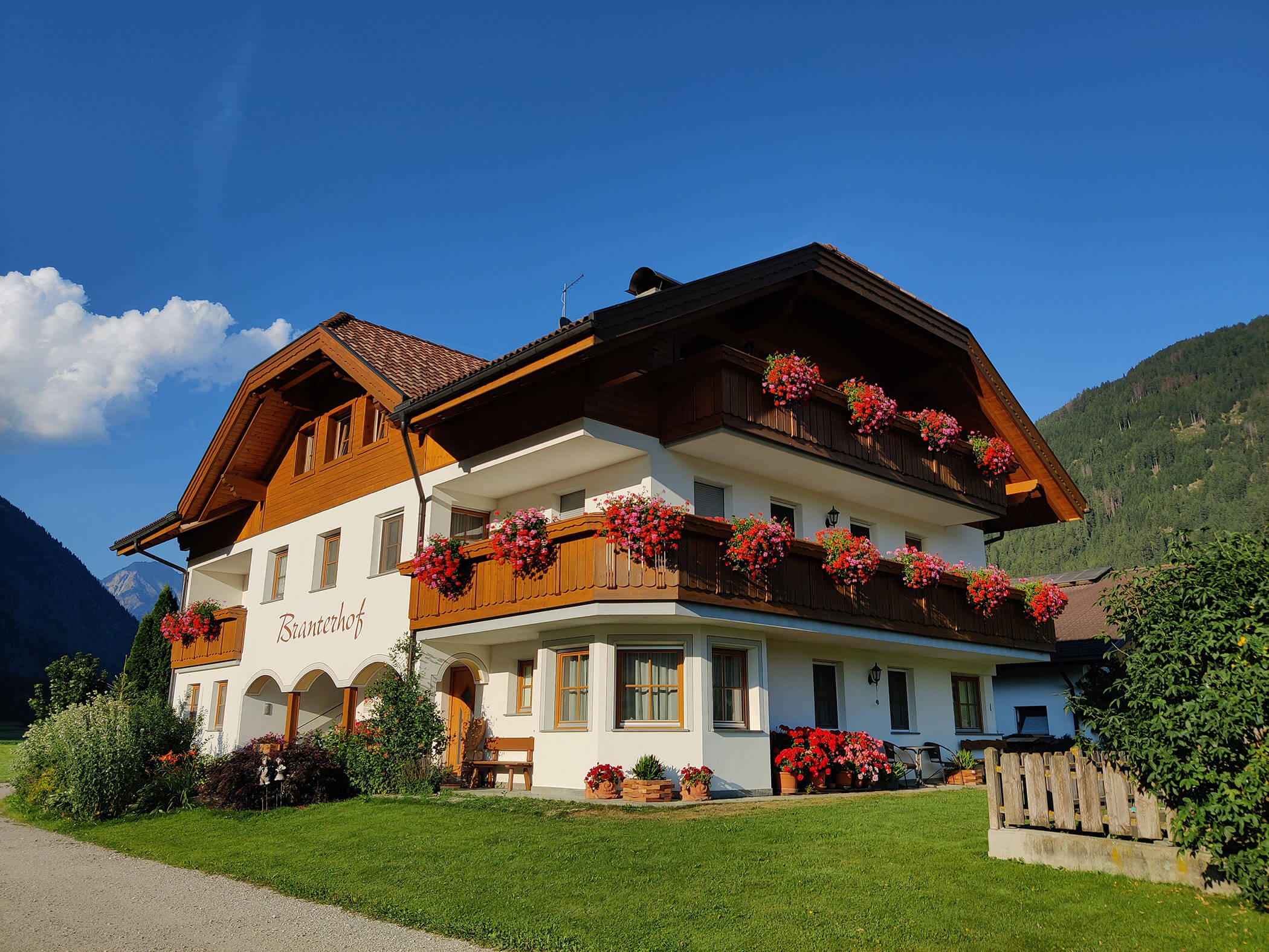 The Branterhof from the outside with colorful flowers on the balconies