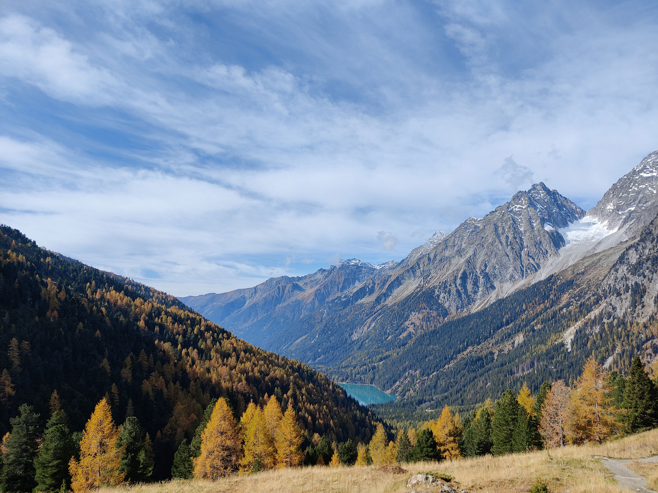 Die Südtiroler Berge im Herbst mit einem hellblauem See im Hintergrund - Branterhof