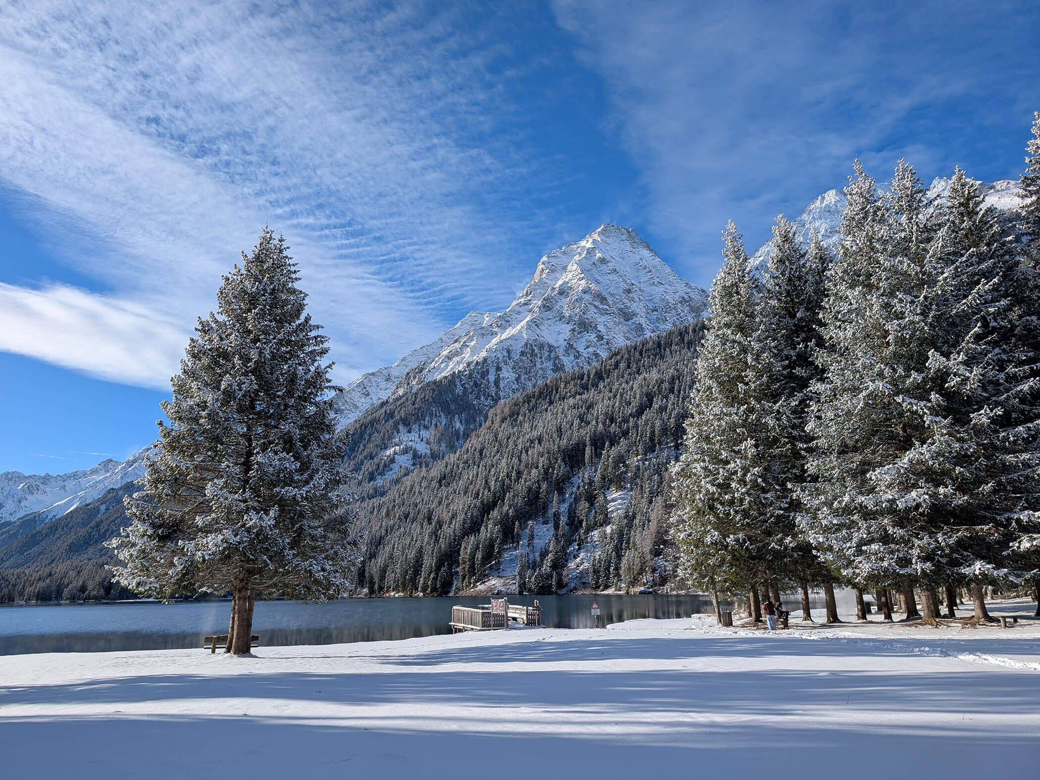 Der Antholzer See mit schneebedeckten Bergen im Hintergrund - Branterhof